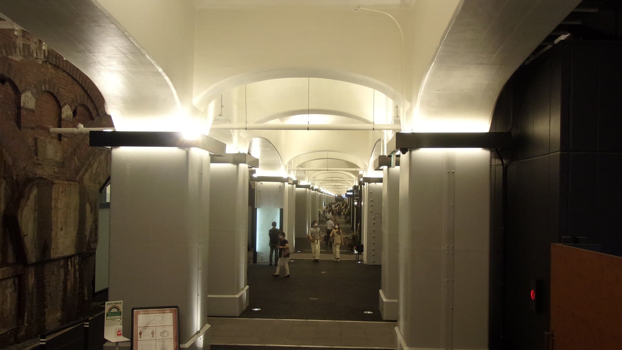 Visitors walking beneath the illuminated railway arches at Hibiya Okuroji